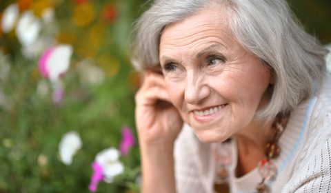 Ältere Dame mit schönen Zähnen genießt das Leben